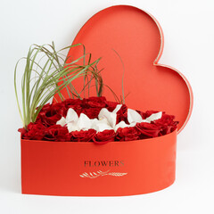 Heart type box with red roses, orchids, cymbidium and beergras.