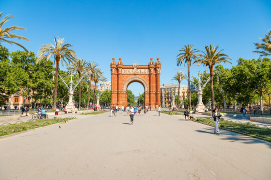Picture of the Triumph Arch of Barcelona captured in a sunny day with people walking through "Lluis Companys" promenade.
