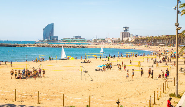 Beautiful picture of Barcelona beach plenty of people enjoying  the sun and summer playing beach sports.
