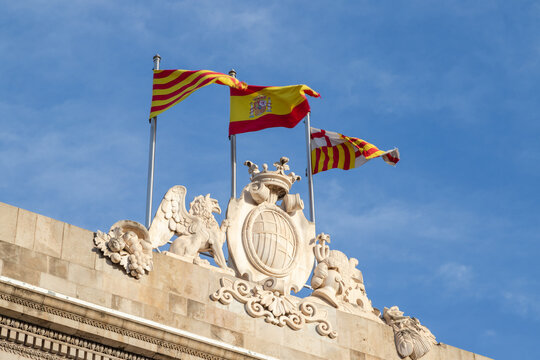 Picture of three flags (Catalonia, Spain, Barcelona) in top of Barcelona's town hall.
