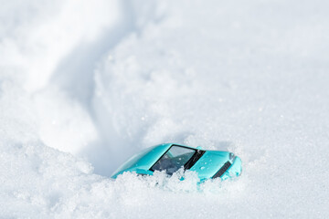 blue toy car stuck in the snow