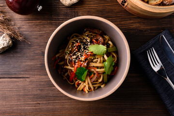 Chinese noodles with beef, muer and vegetables close-up on a plate
