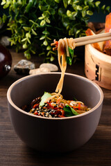 Chinese noodles with beef, muer and vegetables close-up on a plate