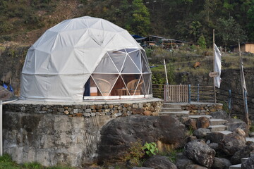 Igloo Tent house in the backdrop of green forest .