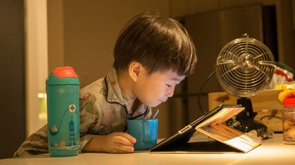 child with fan playing with ipad