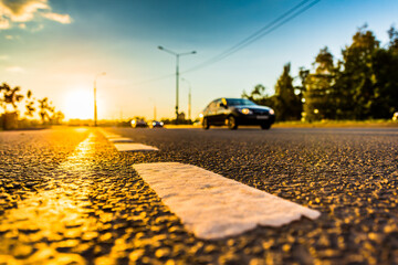 Sunset in the country, the stream of cars passing by on the highway. Wide angle view of the level of the dividing line
