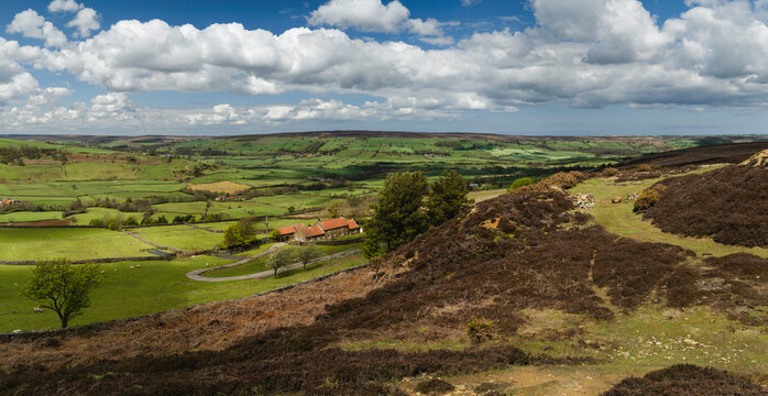 North York Moors with valley, fields, and heathland under blue sky. Glaisdale, UK.