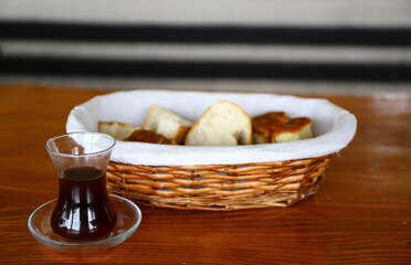 Fototapeta na wymiar Homemade breads sliced and placed in basketnext to a cup of tea.