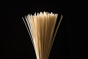 close up of dry noodles made from wheat flour on black background