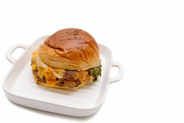 Cheeseburger in white dish, isolated on white background.