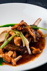 Roasted lamb chops with chanterelles and vegetables on decorated table