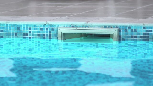 Drainage in a swimming pool with clear water and blue tiles