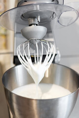 Freshly beaten stiff egg white inside a food processor