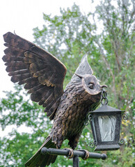 False owl with lantern in a garden 