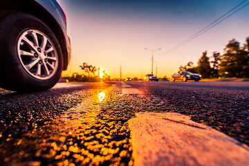 Sunset after rain, the approaching cars on the highway. Wide angle view of the level of the dividing line