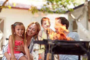beautiful caucasian family of four making fire for barbeque
