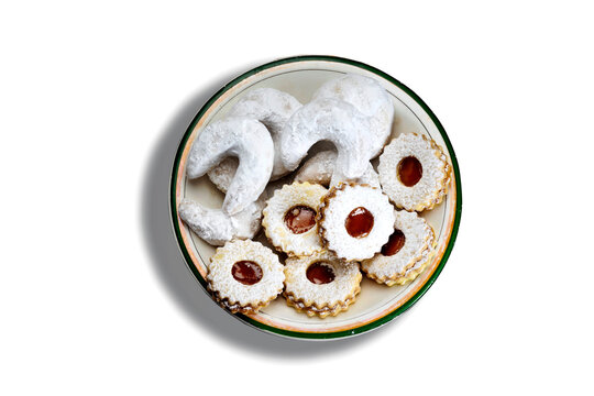 Traditional algerian cookies with apricot jam named in french sablé and kaab el ghazal translated in english : gazelle horns name  in plate isolated on white