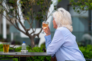 Woman relaxing at a restaurant enjoying a glass of wine