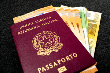 Italian Passport filled with Euro Banknotes on Dark Background. Travel ID and Cash Money. Travel Funds, fifty, hundred and two hundred Euros for Europe Vacation