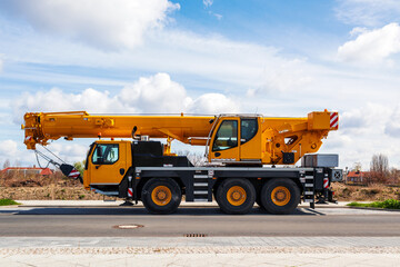 yellow heavy duty mobile crane parked on the roadside. LTM mobile crane. telescopic truck mounted...