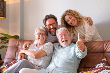 Happy group of family sitting on sofa at home having fun and laughing. Handsome  people, parents...