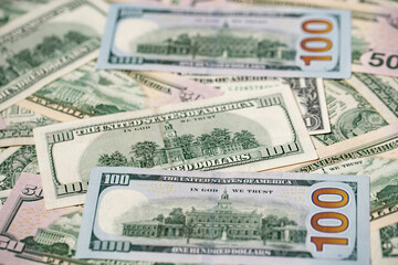 US dollar banknotes as background. One hundred dollar bills spread out. Fifty and 100 USD paper bills