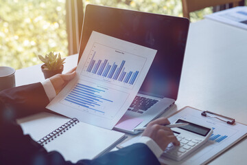 Financial Businesswomen analyze the graph of the company's performance to create profits and...
