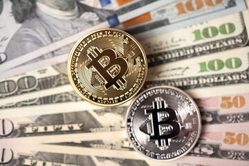 Piled up bitcoin coins on top of US dollar banknotes. Gold and silver BTC coins. Crypto exchange to US dollar concept. Digital crypto currency with paper money