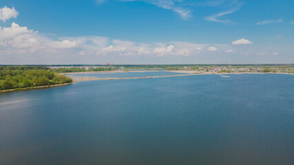 View of the coastline with a beautiful pond from a height. Panoramic photo over blue water. Design of wallpapers, photo wallpapers, backgrounds, screensavers, covers.