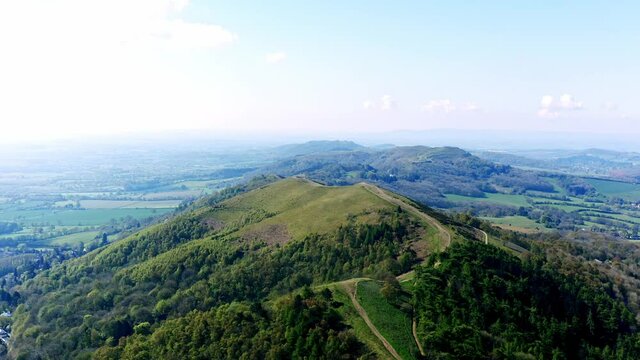 4K Aerial of Malvern Hills, flying above hills, panning motion over the top of the beautiful hills. people walking on the path to the peak