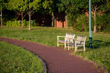 夕日が当たる夏の公園のベンチ
