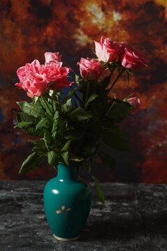 Pink roses in a green vase in the morning light