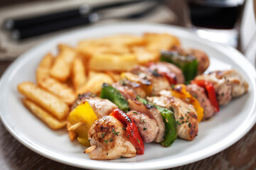 Chicken skewers with fries. High quality photo.
