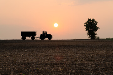 Fototapeta premium Silhouette tractor at hill farm