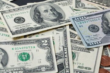 Dollar banknotes spread out. One dollar to one hundred dollar banknotes, rare two dollar in between cash pile. Background with US dollar banknotes. Cash 100 and fifty dollar bills. Dollar Inflation