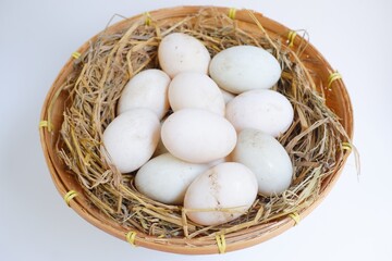 Duck eggs in bamboo basket on white background