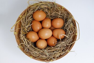 Chicken eggs in bamboo basket on white background
