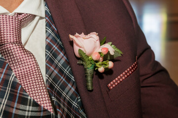 Tie next to the boutonniere on the lapel of a men's suit.