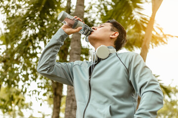 Fototapeta na wymiar Thirsty sport man drinking water after exercise outdoors.