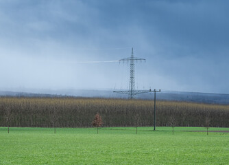 transmission tower  against sky and forest in Germany