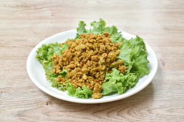 spicy fried chop pork with turmeric and curry on lettuce Thai southern style food in plate