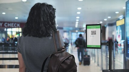 caucasian female shows covid-19 vaccination certificate at the airport,woman traveler holding digital coronavirus health passport at the security control - Powered by Adobe