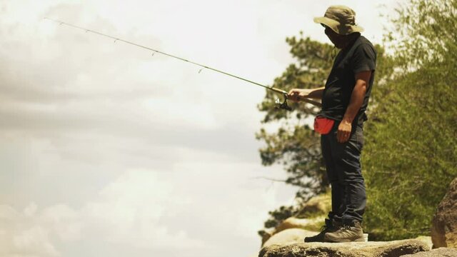 Bored Fisherman fishing from cliff on Big Bear Lake