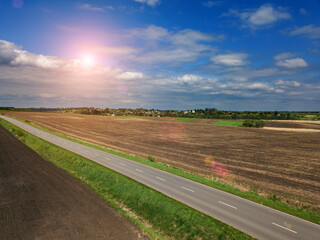 sunset in clouds with sunrays over road to horizon top wiew