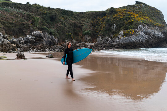 Sportswoman Surfer On Cloudy Beach