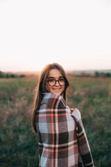 Fille avec un plaid au coucher du soleil