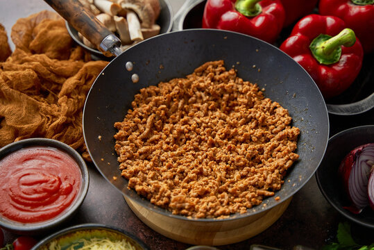 Ingredients on a table prepared for stuffing peppers. Red bell peppers, minced meat, cheese