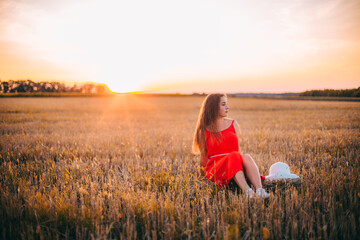 Fille sur un champ de blé au coucher du soleil