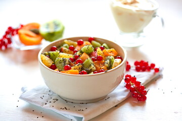 A bowl of fresh berry fruit salad on the white kitchen table. Vegan snack, diet food, healthy food concept. Healthy vegan snack or Breakfast. The concept of weight loss, healthy eating.