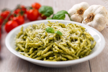 Pasta with pesto sauce and parmesan on a plate.